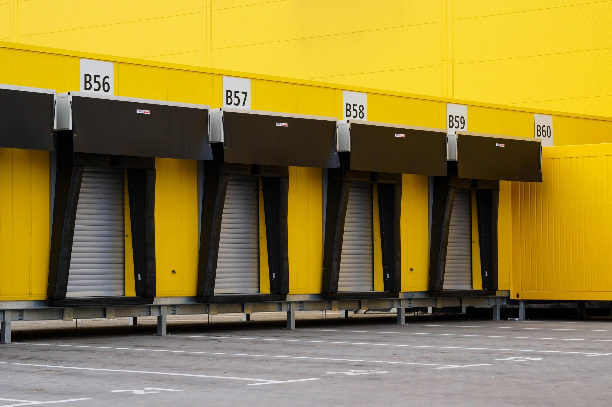 Yellow warehouse loading dock doors numbered B56 to B60